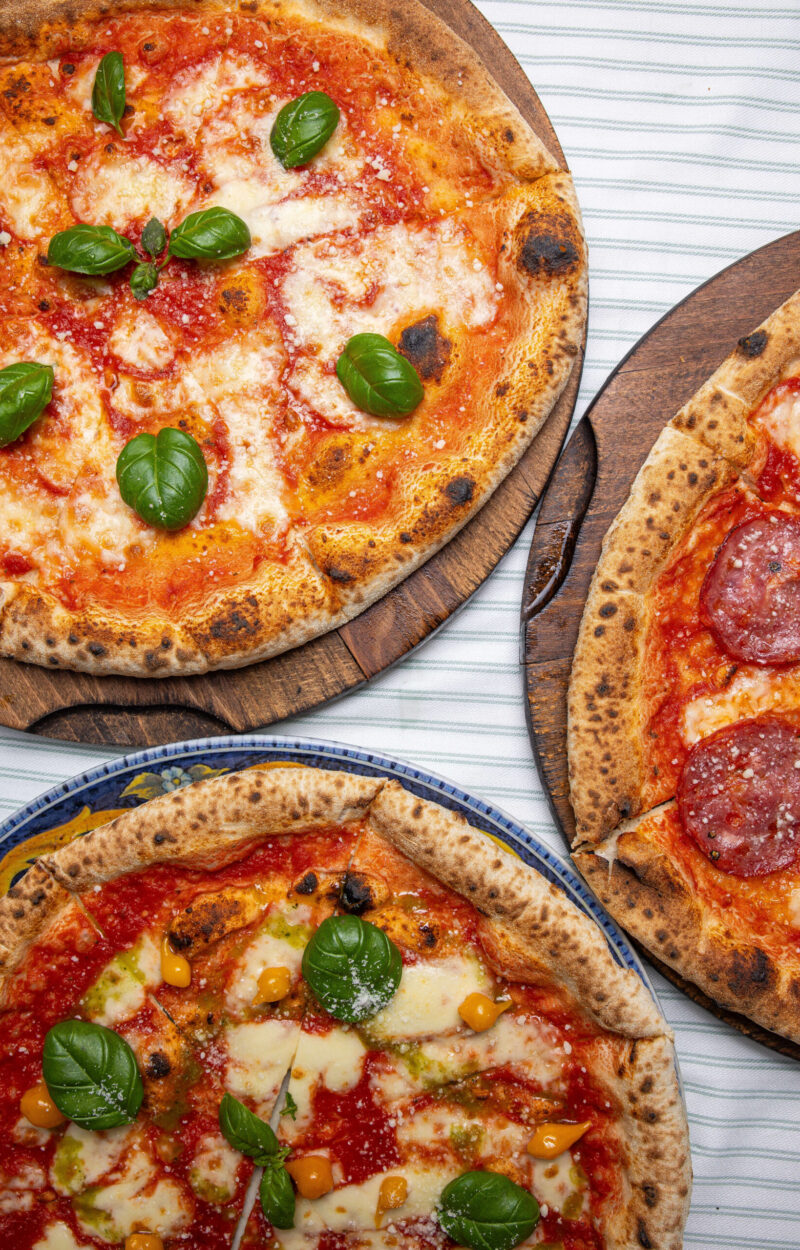 three-mouth-watering-neapolitan-pizzas-with-fresh-basil-assorted-toppings